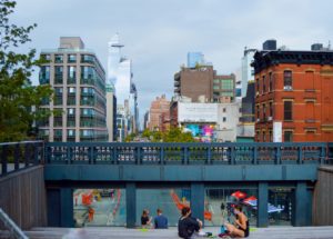 a group of people sitting on the ground under a bridge